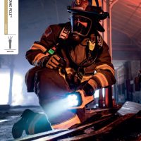 Copertă catalog Lanterne Peli, unde un pompier folosește o lanternă Peli pentru a vedea într-o clădire afectată de incendiu.